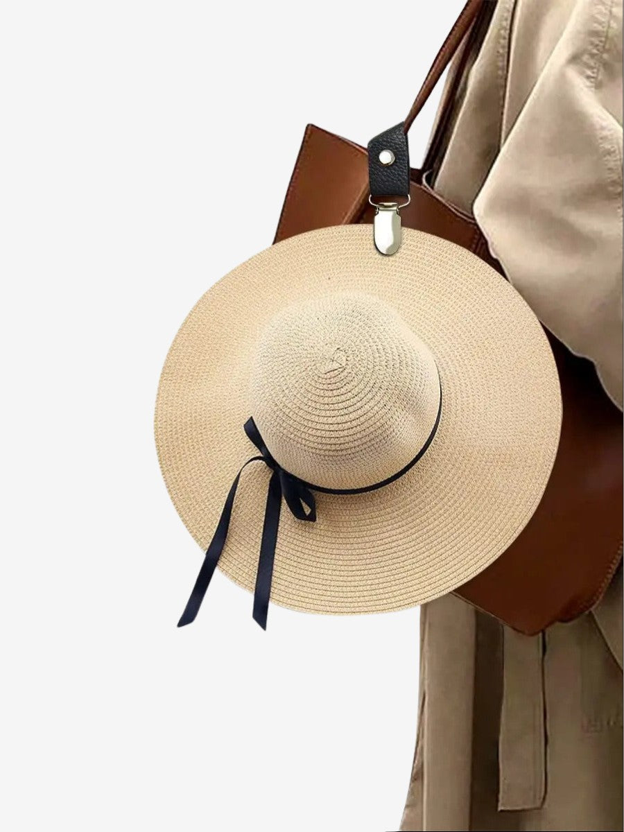 femme avec un sac et un Attache Chapeau  qui attache son chapeau de paille